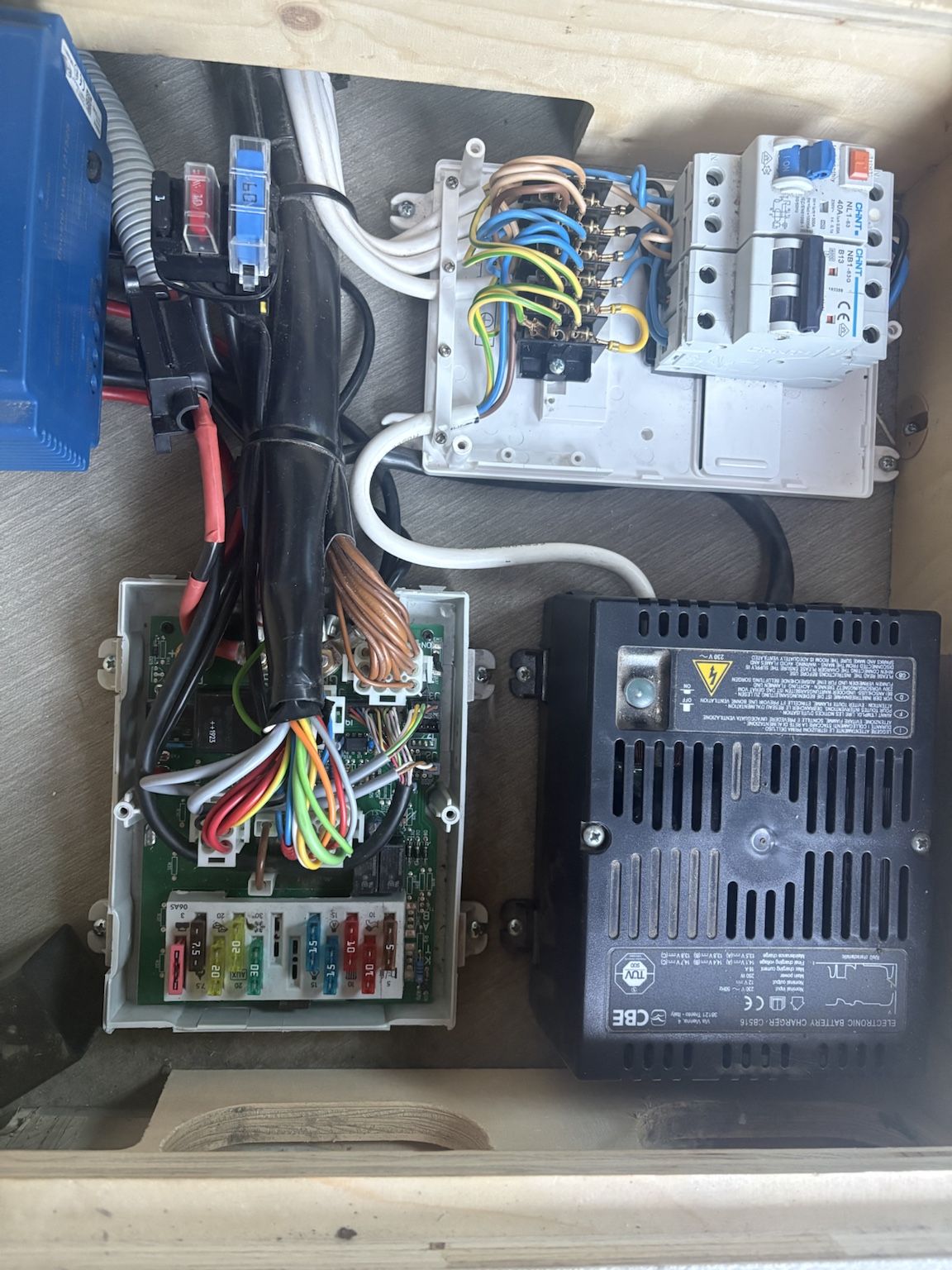 Geöffnete CBE DS300 mit Sicherungsleiste, dichtem Kabelbaum und mehreren kräftigen Anschlussleitungen. Im Bereich der beiden Batterieanschlüsse verläuft ein zusätzliches rot geschütztes Kabel sehr eng an den benachbarten Kontakten.